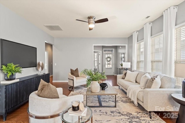 living area featuring ceiling fan, a wealth of natural light, and wood finished floors