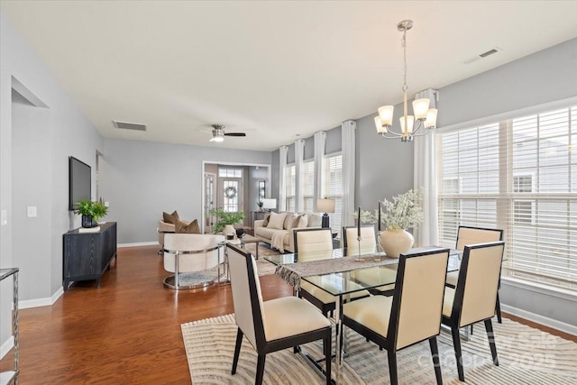 dining space featuring baseboards, wood finished floors, and visible vents
