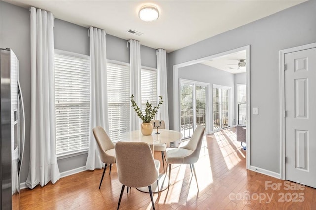 dining area featuring wood finished floors, visible vents, and baseboards