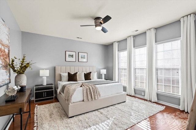 bedroom featuring wood finished floors, visible vents, and a ceiling fan
