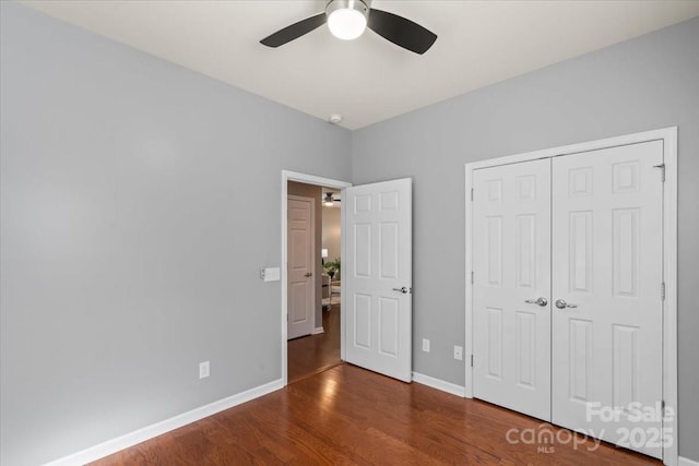 unfurnished bedroom with baseboards, a ceiling fan, wood finished floors, and a closet