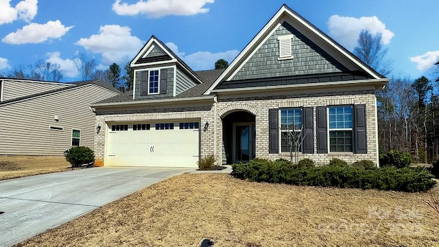 view of front of house featuring a garage, concrete driveway, brick siding, and a standing seam roof