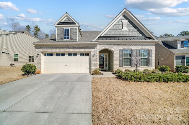 view of front of house featuring driveway, brick siding, a standing seam roof, and an attached garage