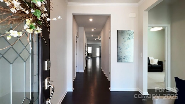 foyer with ornamental molding, dark wood finished floors, and baseboards