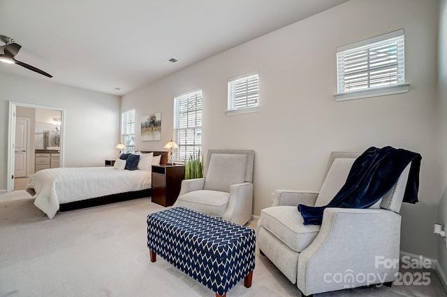 bedroom featuring light colored carpet, visible vents, and ensuite bathroom