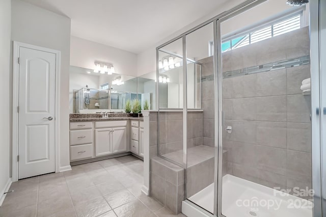 full bathroom with a stall shower, vanity, and tile patterned floors