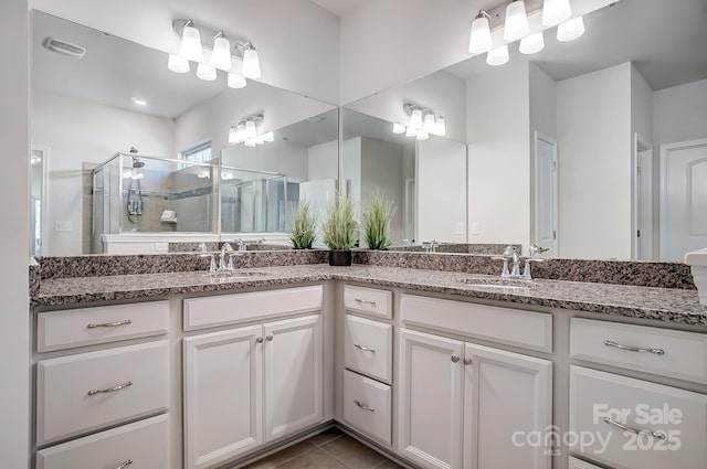 full bathroom with double vanity, a sink, visible vents, and a shower stall