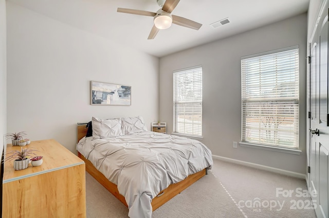 bedroom featuring light carpet, ceiling fan, visible vents, and baseboards