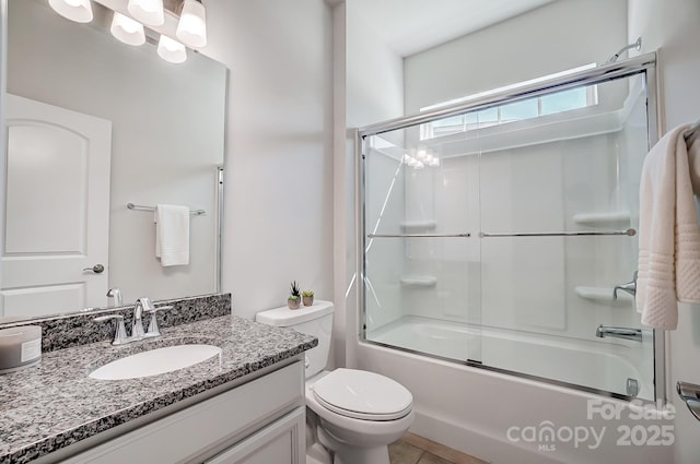 bathroom with toilet, shower / bath combination with glass door, and vanity