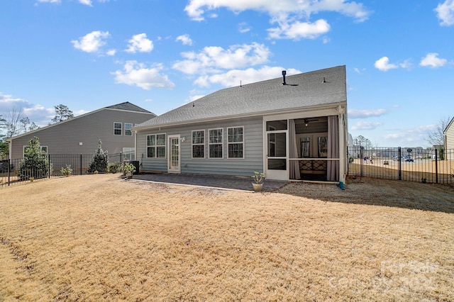 back of house with a shingled roof, a fenced backyard, and a sunroom