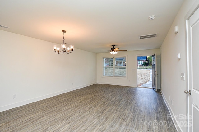 spare room with ceiling fan with notable chandelier, visible vents, baseboards, and wood finished floors