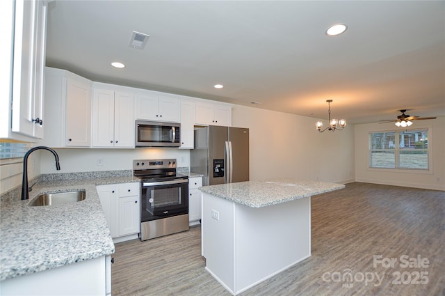 kitchen featuring stainless steel appliances, a sink, visible vents, and white cabinetry