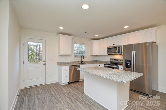 kitchen featuring appliances with stainless steel finishes, recessed lighting, a sink, and light wood-style flooring