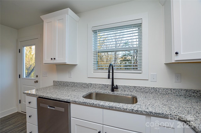 kitchen featuring white cabinets, dishwasher, a sink, and light stone countertops