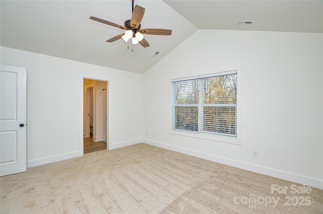 unfurnished room with carpet flooring, vaulted ceiling, visible vents, and baseboards