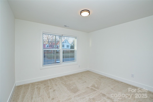 carpeted empty room with visible vents and baseboards