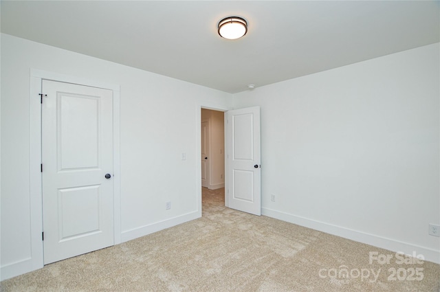 carpeted empty room with baseboards