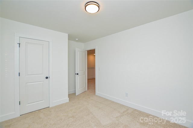 unfurnished bedroom featuring carpet floors and baseboards