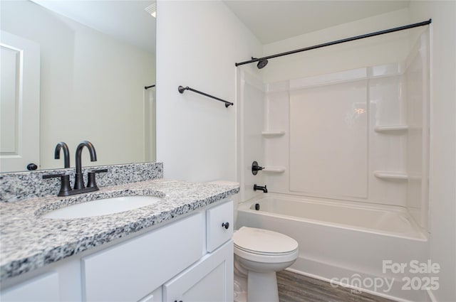 bathroom featuring vanity, tub / shower combination, wood finished floors, and toilet