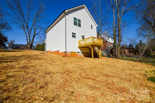 view of home's exterior with stairway, crawl space, a wooden deck, and fence