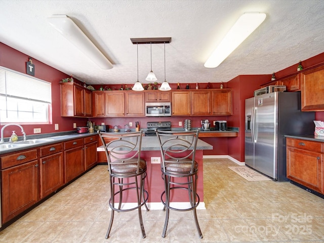 3841 Shasta Cir, Clover, SC 29710 - kitchen with stainless steel appliances, a sink, a kitchen island, a kitchen bar, and brown cabinets