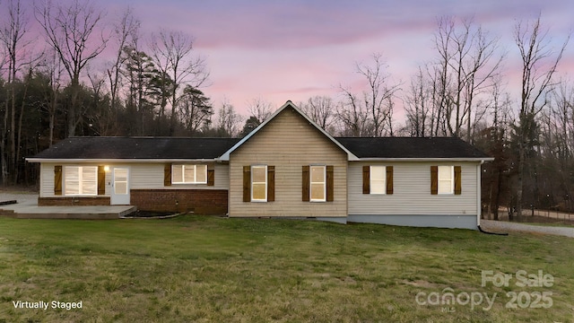 ranch-style house with a lawn and brick siding