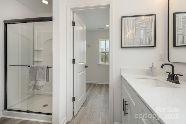 bathroom featuring a stall shower, visible vents, wood finished floors, vanity, and recessed lighting