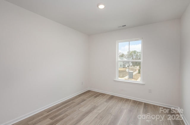 unfurnished room featuring light wood-style floors, baseboards, and visible vents