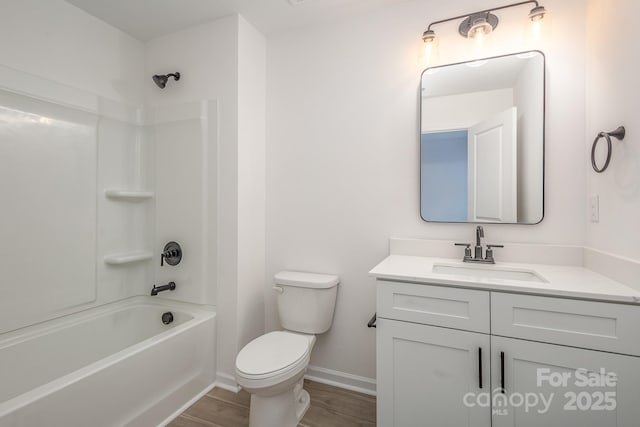 full bath featuring toilet, wood finished floors, vanity, baseboards, and tub / shower combination