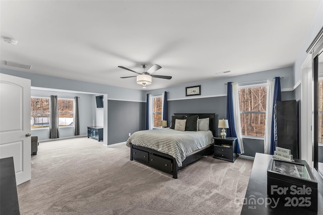 carpeted bedroom with visible vents and a ceiling fan