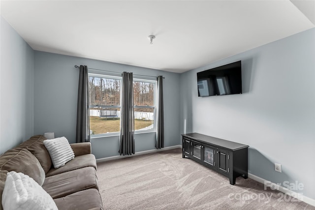 living room featuring baseboards and light colored carpet