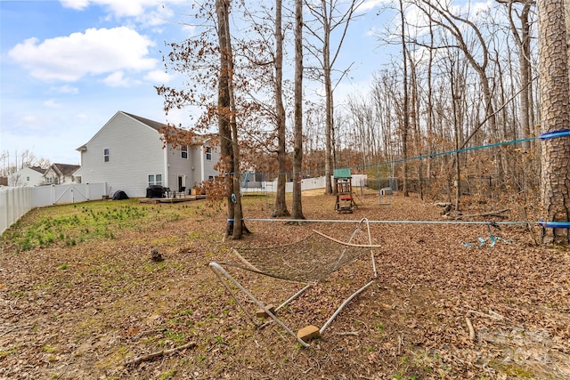 view of yard featuring fence and a playground