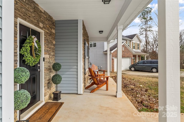 view of patio featuring covered porch and a garage