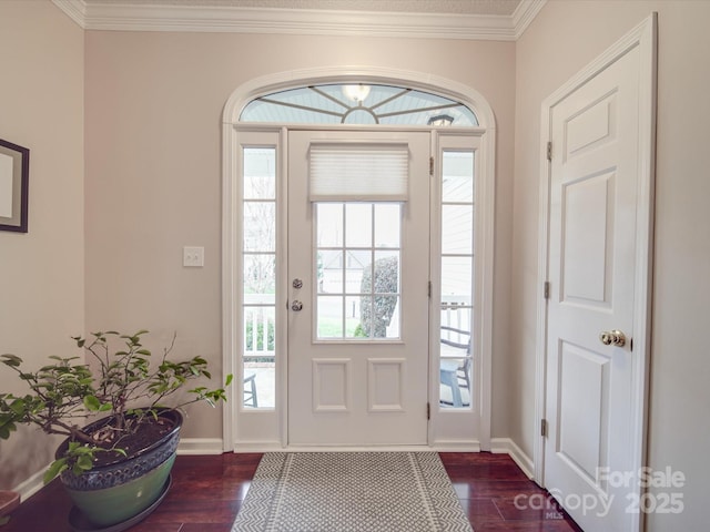 foyer entrance with ornamental molding, dark wood-style flooring, and baseboards