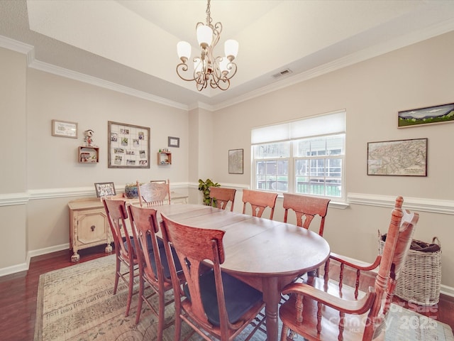 dining space with dark wood-style flooring, visible vents, crown molding, and baseboards