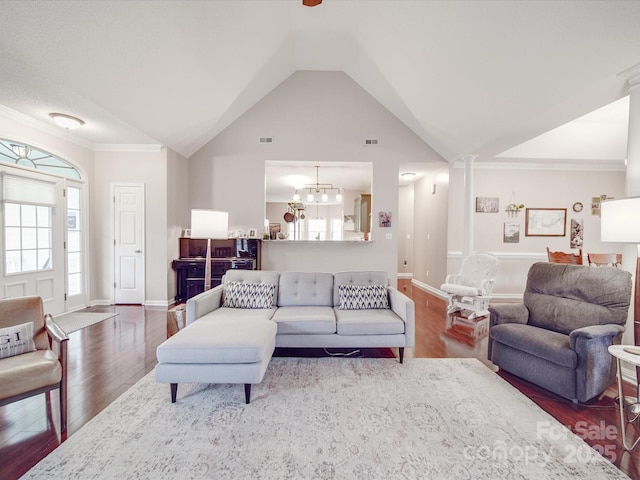 living room with baseboards, dark wood-style floors, an inviting chandelier, vaulted ceiling, and ornate columns