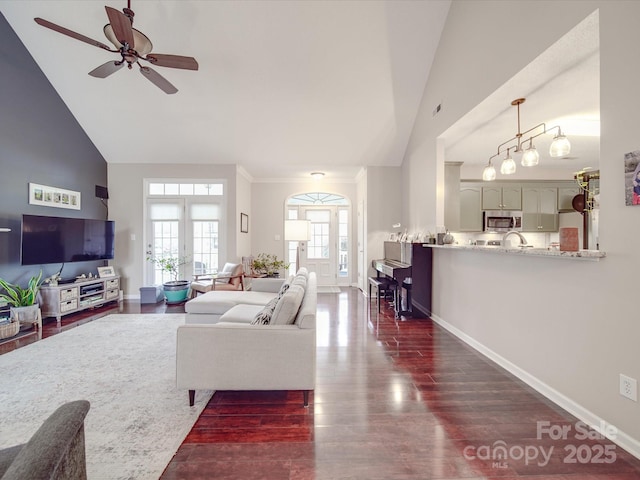 living area featuring dark wood-style floors, high vaulted ceiling, and baseboards