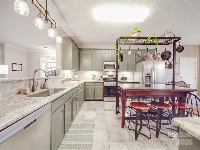 kitchen featuring decorative backsplash, stainless steel appliances, pendant lighting, a sink, and light tile patterned flooring