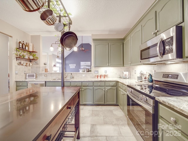 kitchen with appliances with stainless steel finishes, decorative backsplash, and green cabinetry