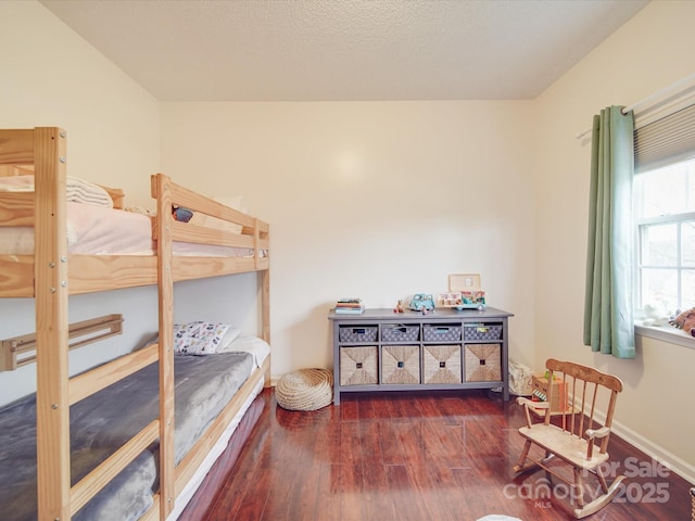 bedroom with baseboards and dark wood-style flooring