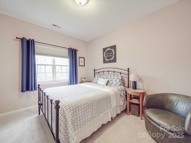 bedroom with light carpet, baseboards, visible vents, and a textured ceiling