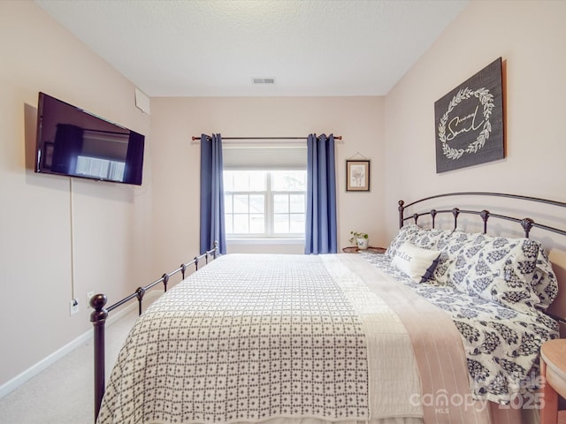 carpeted bedroom with a textured ceiling, visible vents, and baseboards