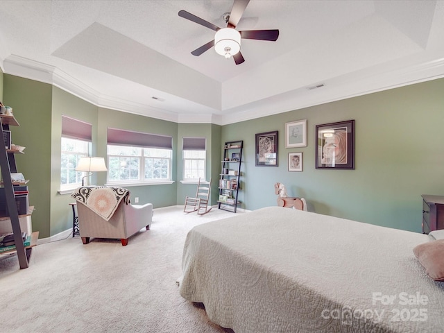 bedroom with a raised ceiling, ornamental molding, a ceiling fan, carpet flooring, and baseboards