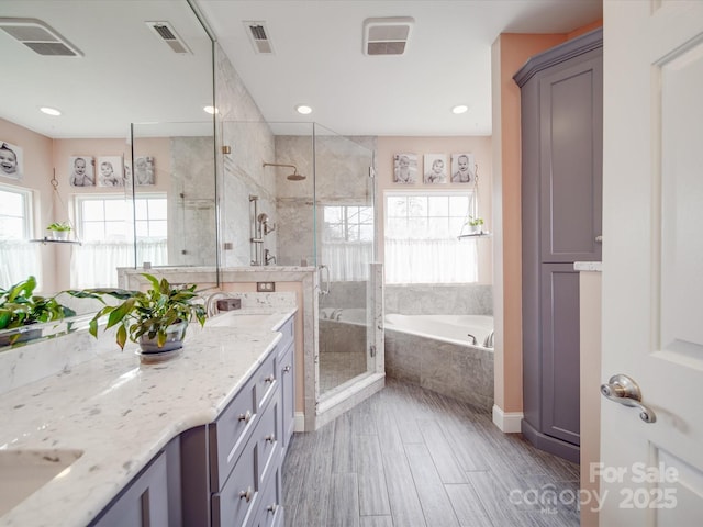 full bath with a stall shower, visible vents, a garden tub, and vanity