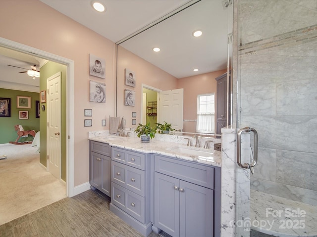 ensuite bathroom featuring connected bathroom, a sink, a shower stall, and double vanity