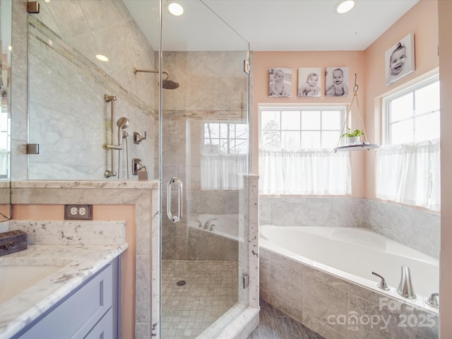 bathroom with a shower stall, vanity, and a bath