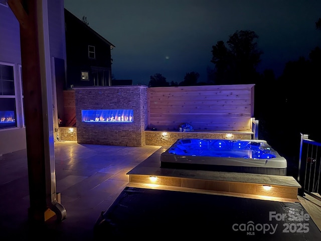 patio at twilight with an outdoor hot tub