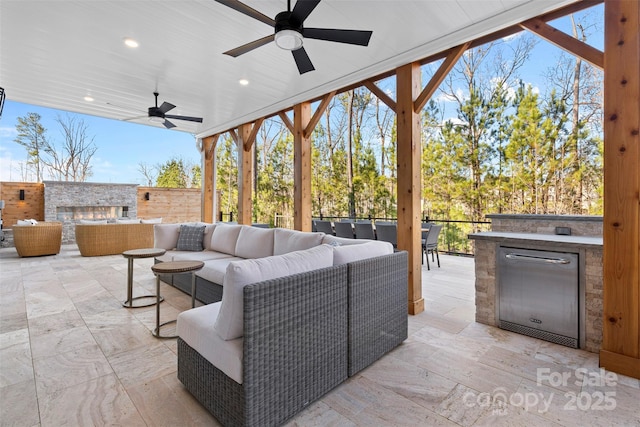 view of patio / terrace with an outdoor living space, a ceiling fan, and area for grilling