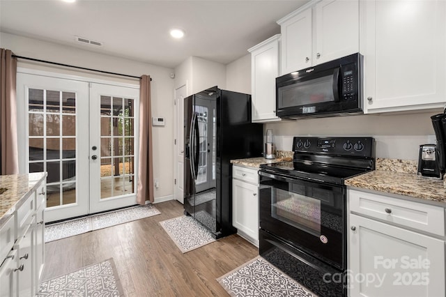 kitchen featuring visible vents, light wood-style floors, french doors, black appliances, and white cabinetry