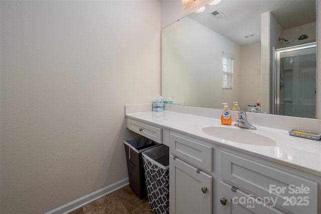 bathroom featuring a shower with shower door, visible vents, vanity, and baseboards